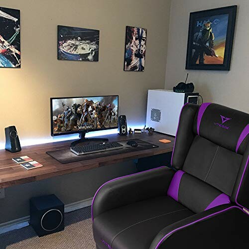 Modern gaming setup with large monitor, speakers, and gaming chair.