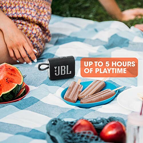 JBL speaker on picnic blanket with watermelon and popsicles.