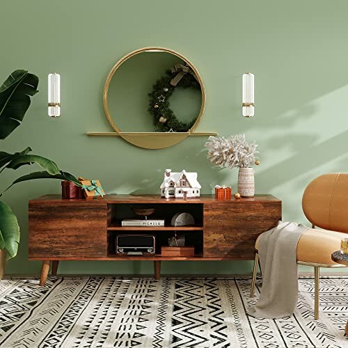 Stylish living room with green wall, round mirror, wooden sideboard, and decorative items.