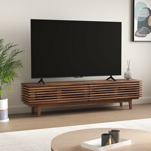 A modern wooden TV stand with a flat-screen TV and decorative items.