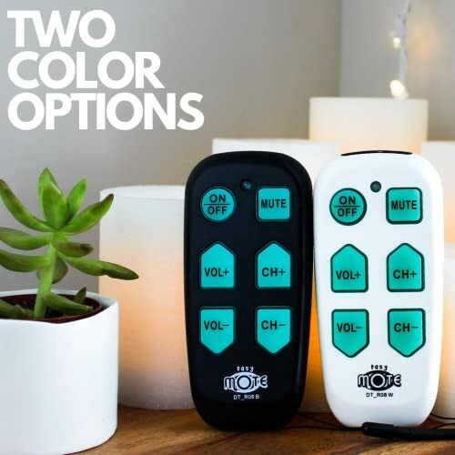 Two remote controls in black and white with candles and a plant.