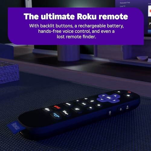 Roku remote with backlit buttons on a table.