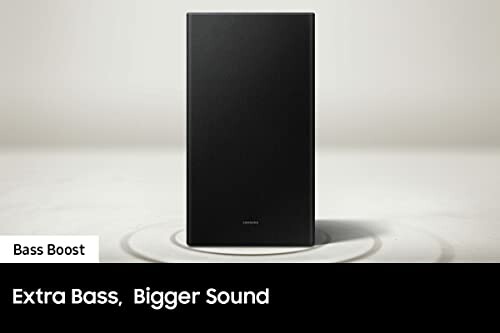 Black speaker on a white surface with text 'Extra Bass, Bigger Sound.'