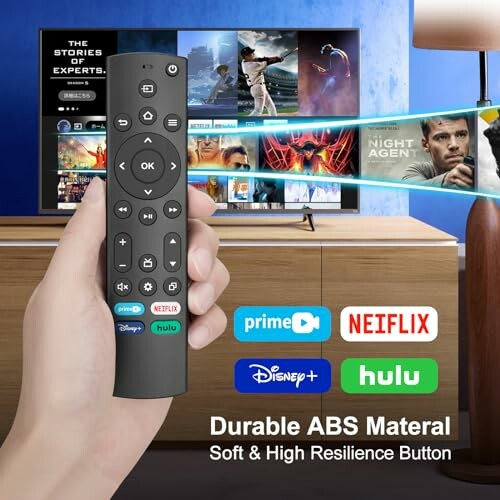 Hand holding remote control with streaming services icons on TV screen.